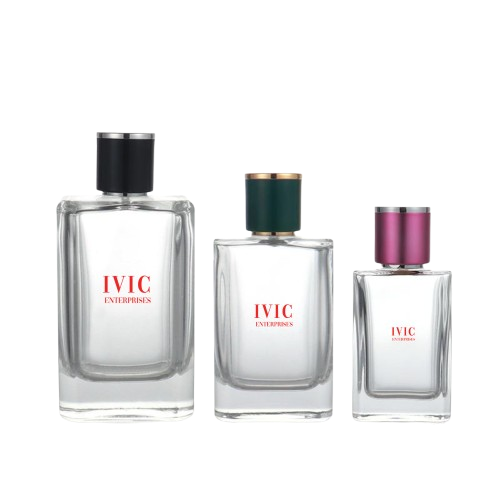 Three clear glass perfume bottles of varying sizes with different colored caps—black, green, and pink—stand side by side from Ivic Enterprises