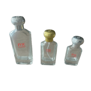 Three clear glass perfume bottles of varying sizes with metallic caps of ivic enterprises